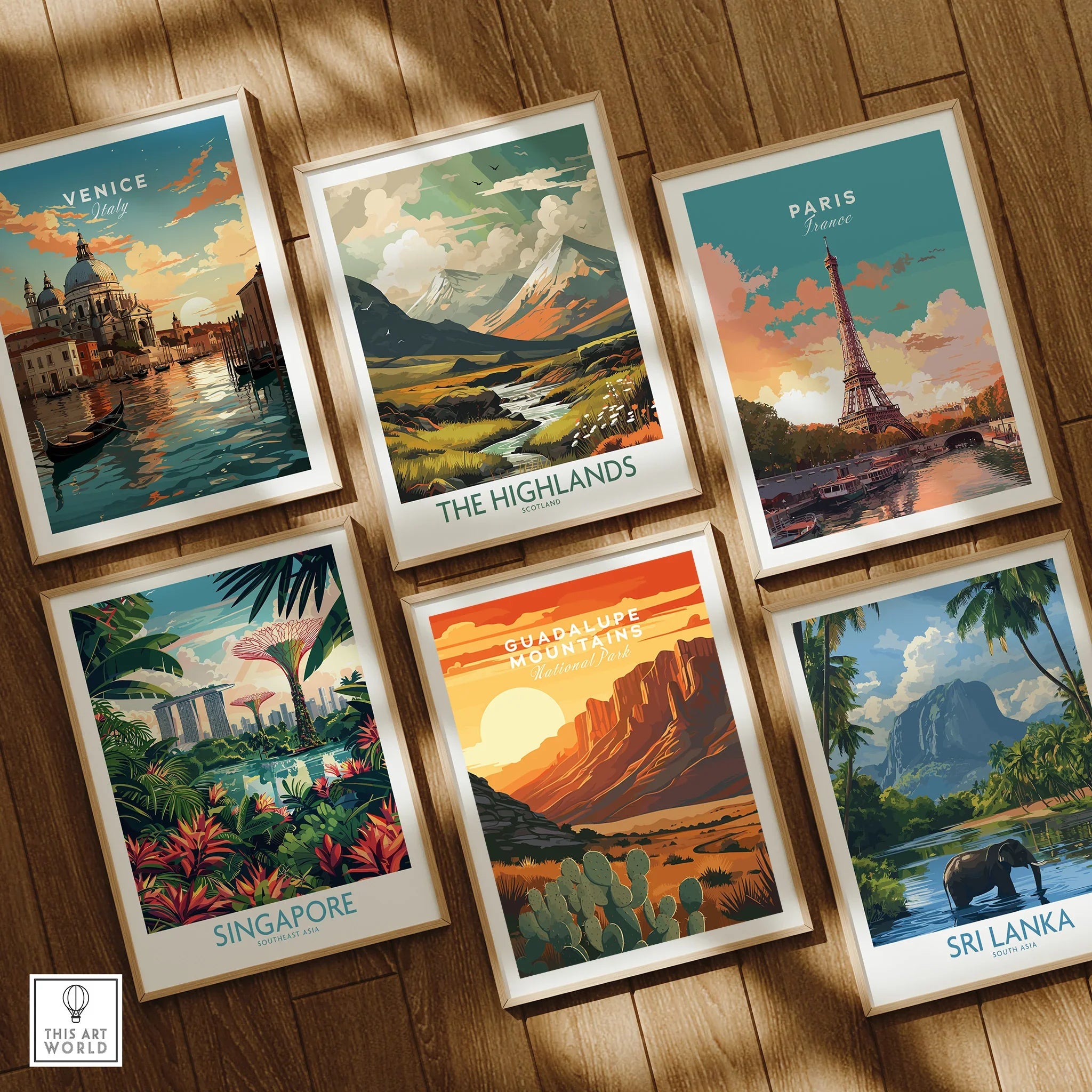 Set of six framed travel posters featuring Venice, Paris, the Highlands, Singapore, Guadalupe Mountains, and Sri Lanka, displayed on a wooden floor.