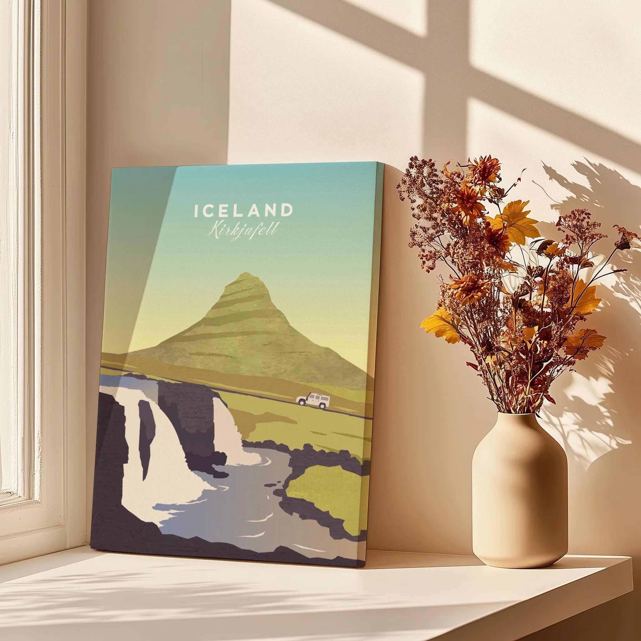 Iceland Kirkjufell travel poster print with mountain, waterfall, and car, styled on windowsill with dried flowers.
