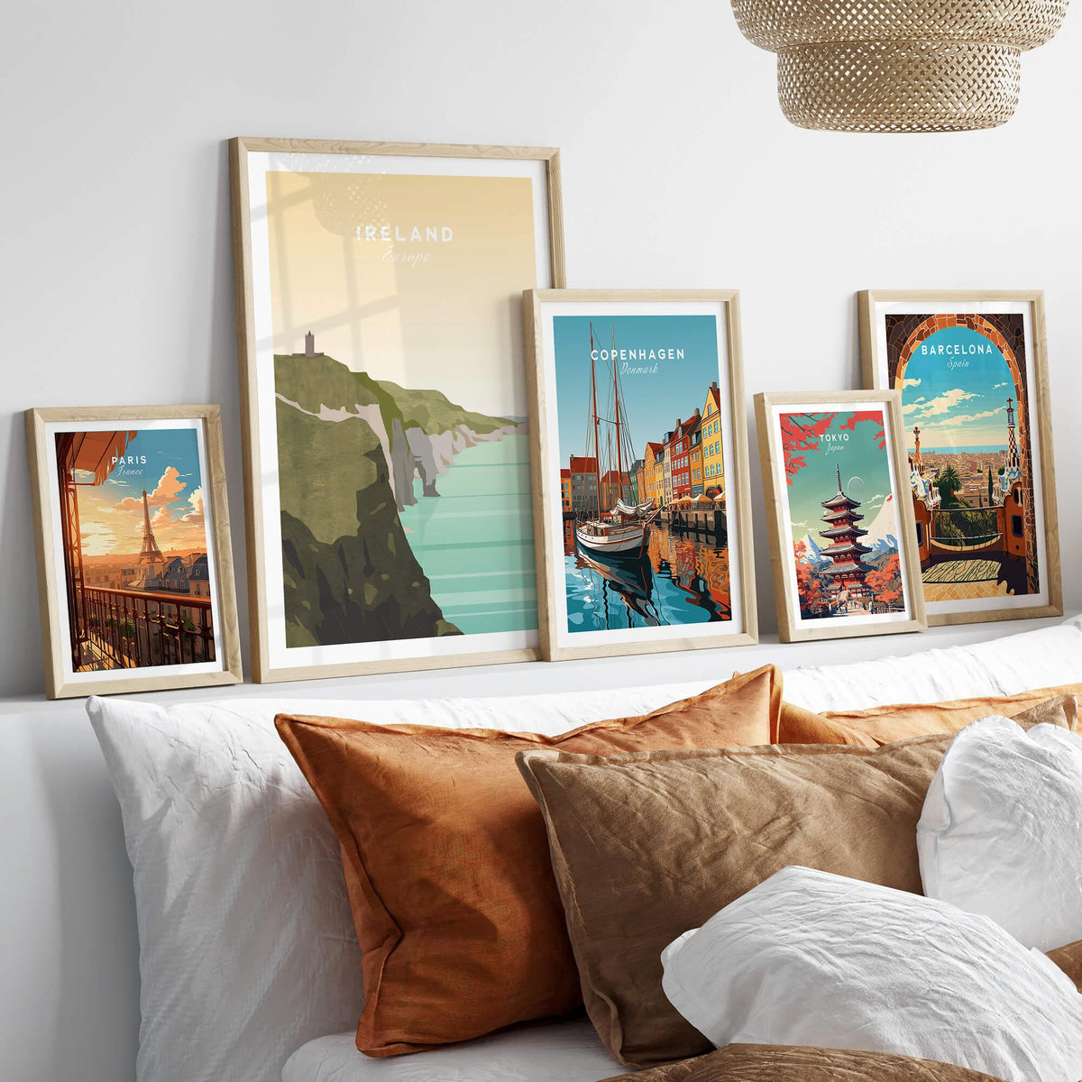 Framed travel posters of Ireland, Paris, Copenhagen, Tokyo, and Barcelona above a modern bed