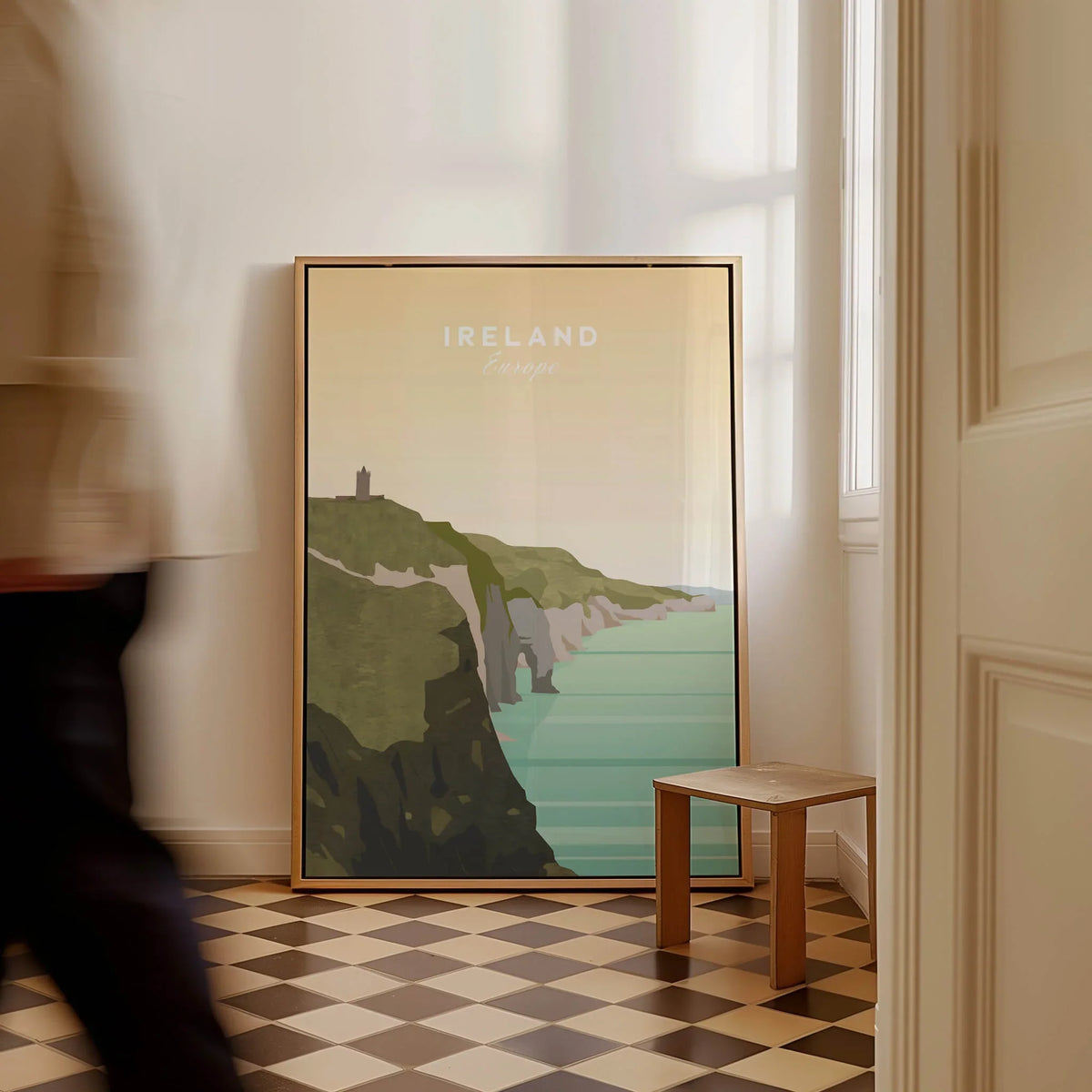 Ireland travel poster with scenic coastal cliffs and sea, leaning against a wall in a sunlit room