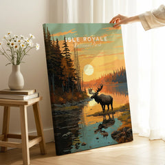 Hand holding Isle Royale National Park art print with moose, forest, and sunset scene