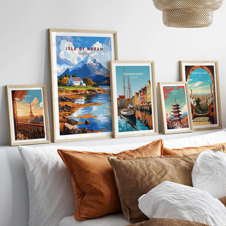 Isle of Arran print showcasing Scotland's landscapes, framed decor on a bed beside other city prints.