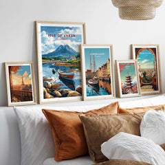 Isle of Arran Scotland Travel Print surrounded by other travel prints on a sofa, showcasing vibrant scenic designs.
