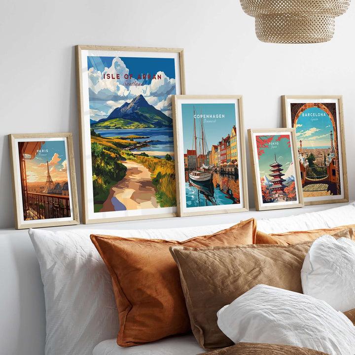 Framed Isle of Arran Scotland wall art among vibrant travel-themed prints on a stylish bed setting.