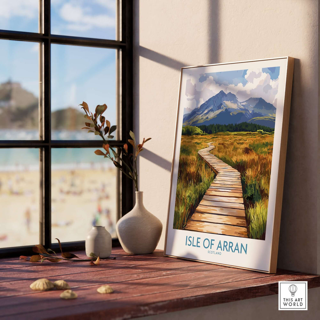 Isle of Arran wall art print displayed on a wooden table beside a window, showcasing Scottish island scenery.