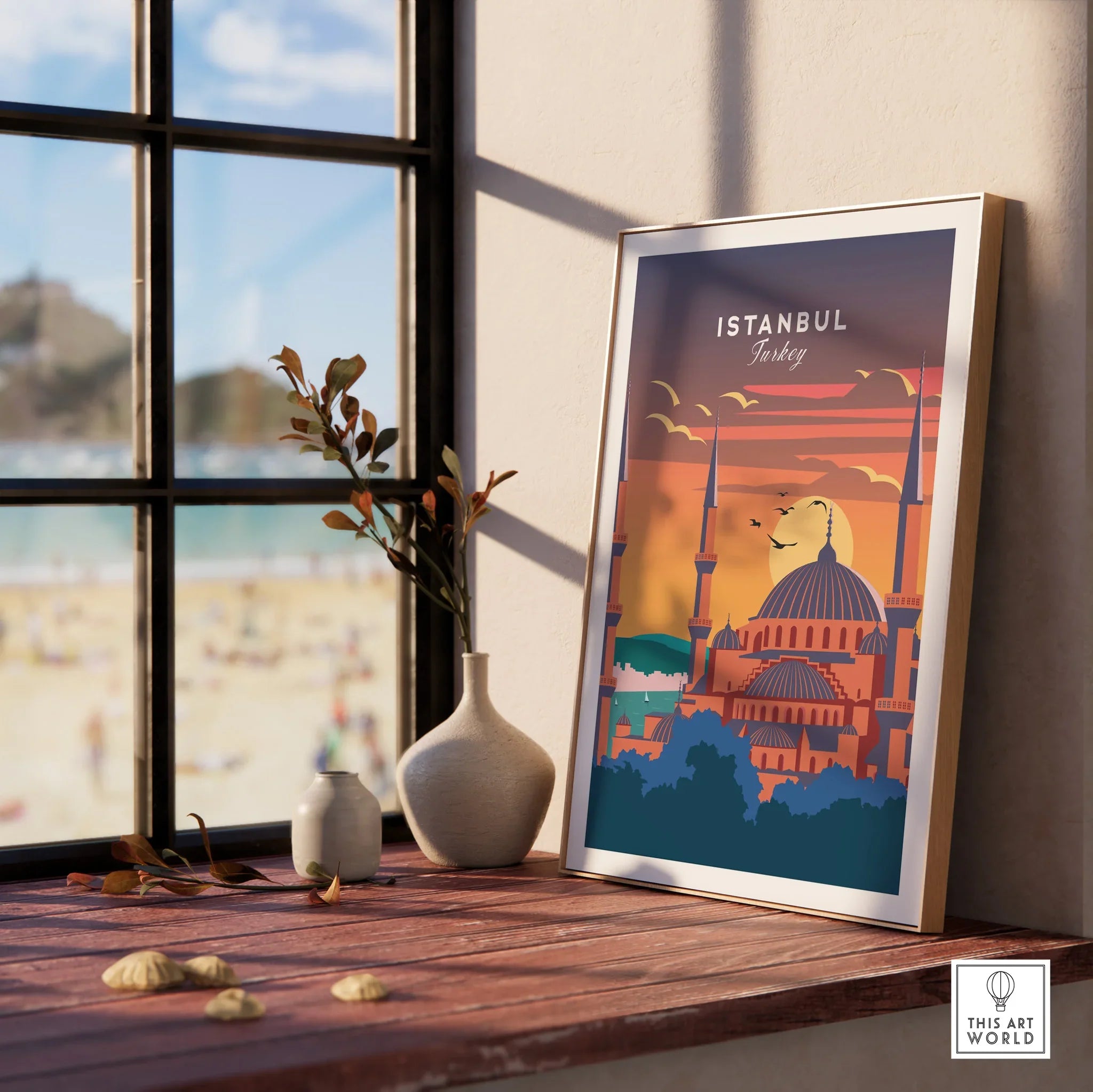 Istanbul Turkey travel poster with mosque skyline, sunset, and birds, framed on windowsill near beach view