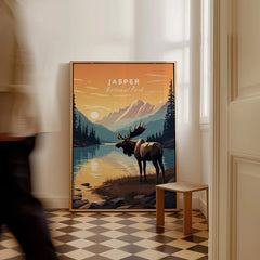 Jasper National Park travel poster with moose and mountain lake, framed and resting on floor