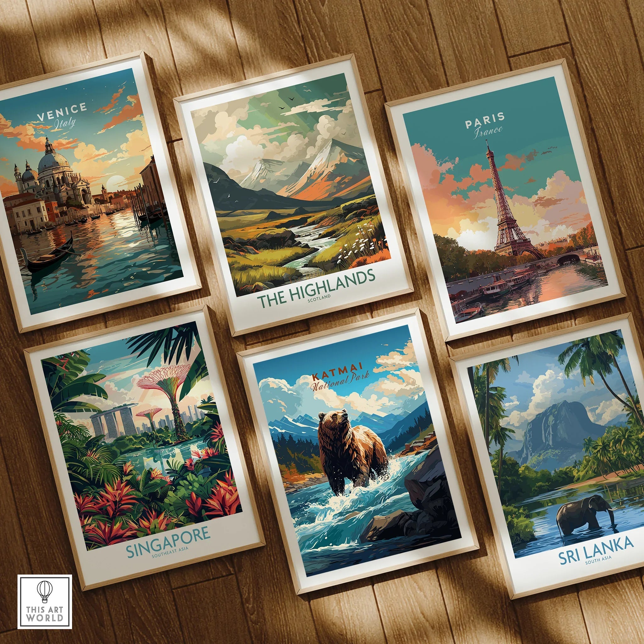 Set of six framed travel posters featuring Venice, Paris, Scotland, Singapore, Katmai National Park, and Sri Lanka, displayed on a wooden floor.