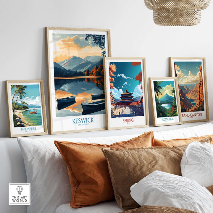 Framed Keswick Art Print among other travel prints on a stylish sofa, showcasing beautiful landscapes.