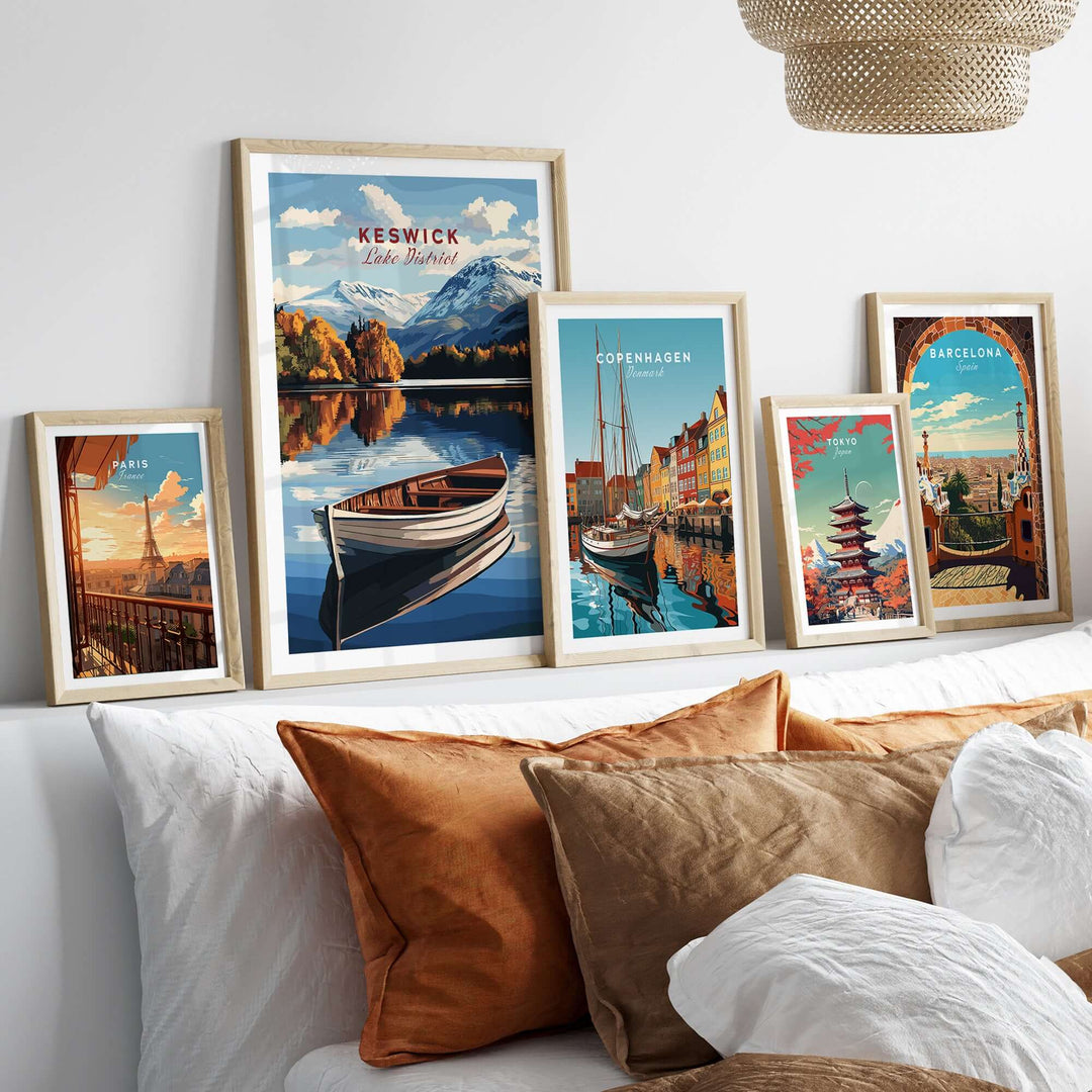 Framed Keswick Print showcasing Lake District scenery, accompanied by prints from Copenhagen and Barcelona, decor on a stylish bed.