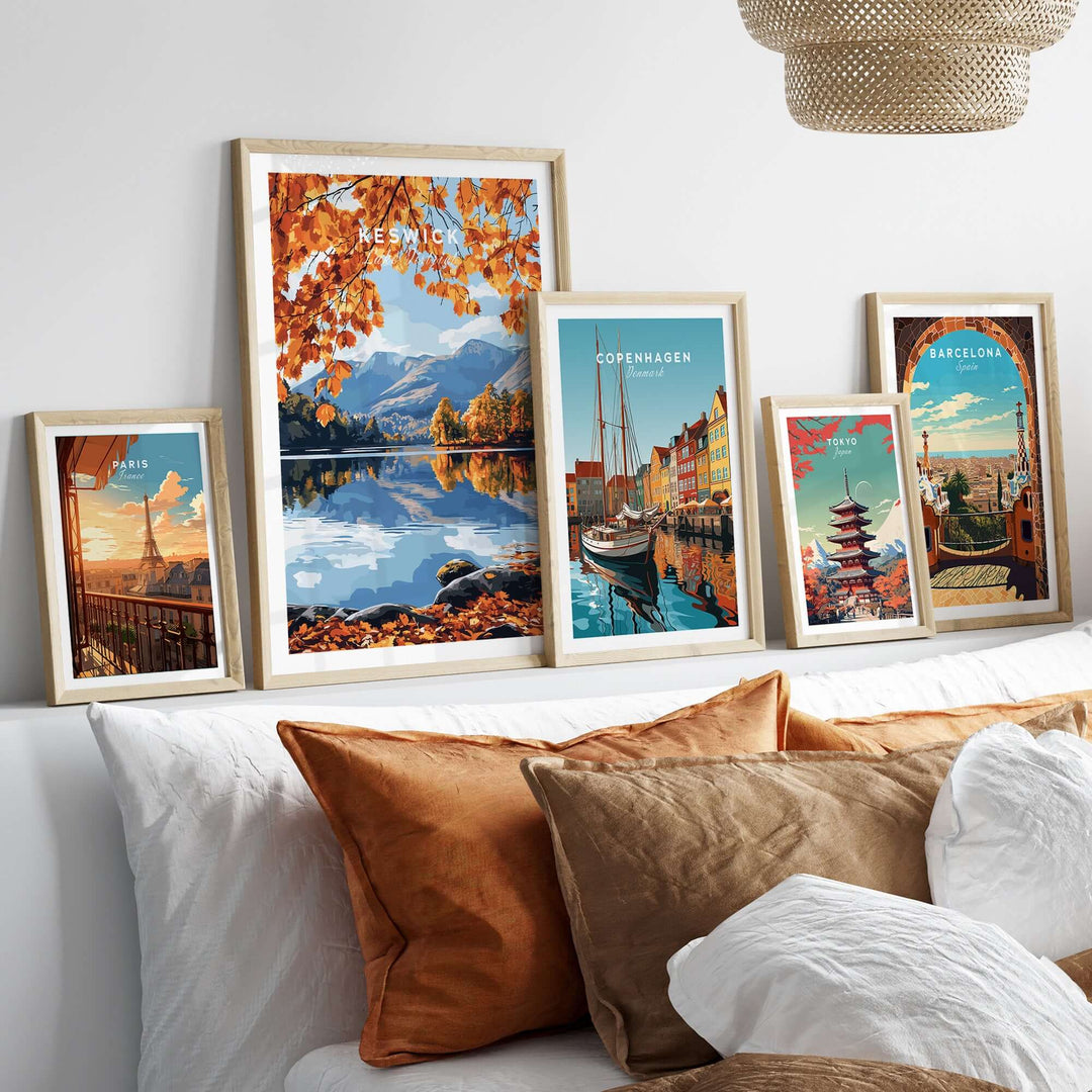 Gallery of travel prints featuring Keswick, Copenhagen, and Barcelona displayed on a stylish wall above decorative pillows.