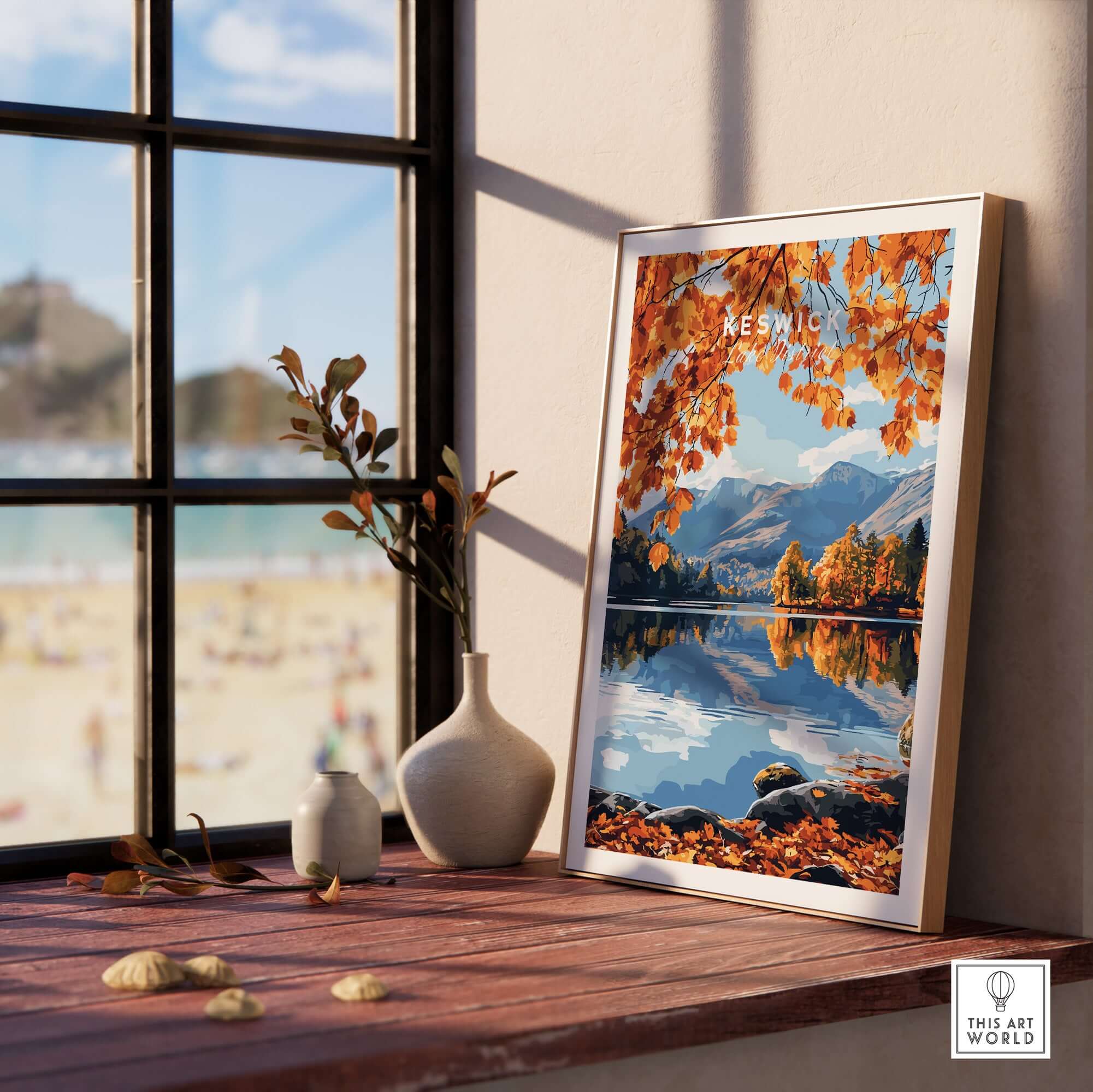 Keswick Travel Print showcased on a windowsill with autumn leaves and a serene lake view in the background.