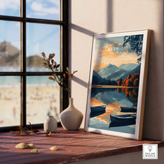 Keswick Wall Art Poster displayed on a wooden shelf with mountains and lake reflecting in the background.