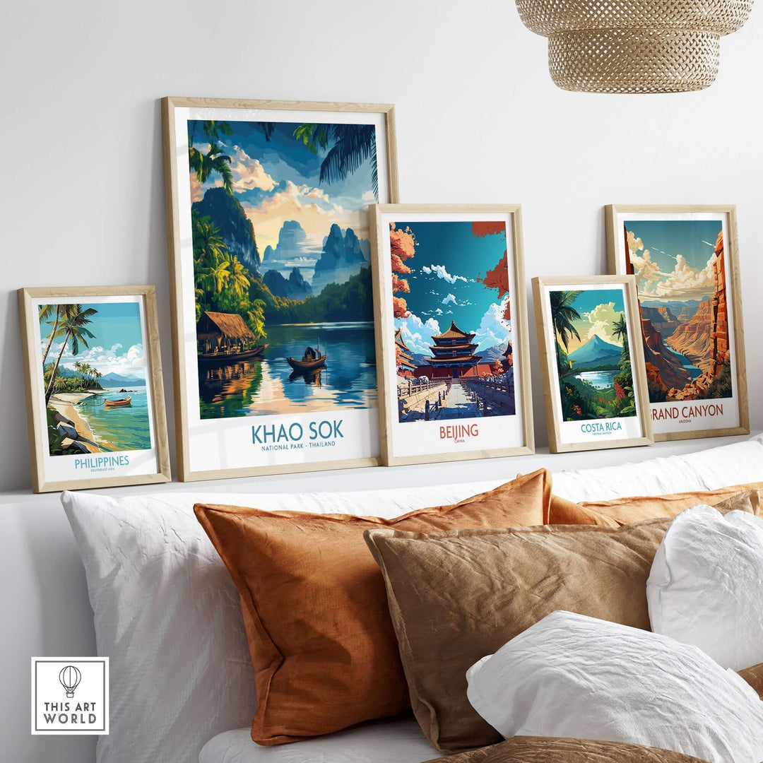 Khao Sok travel poster displayed among framed artworks of various destinations on a couch.