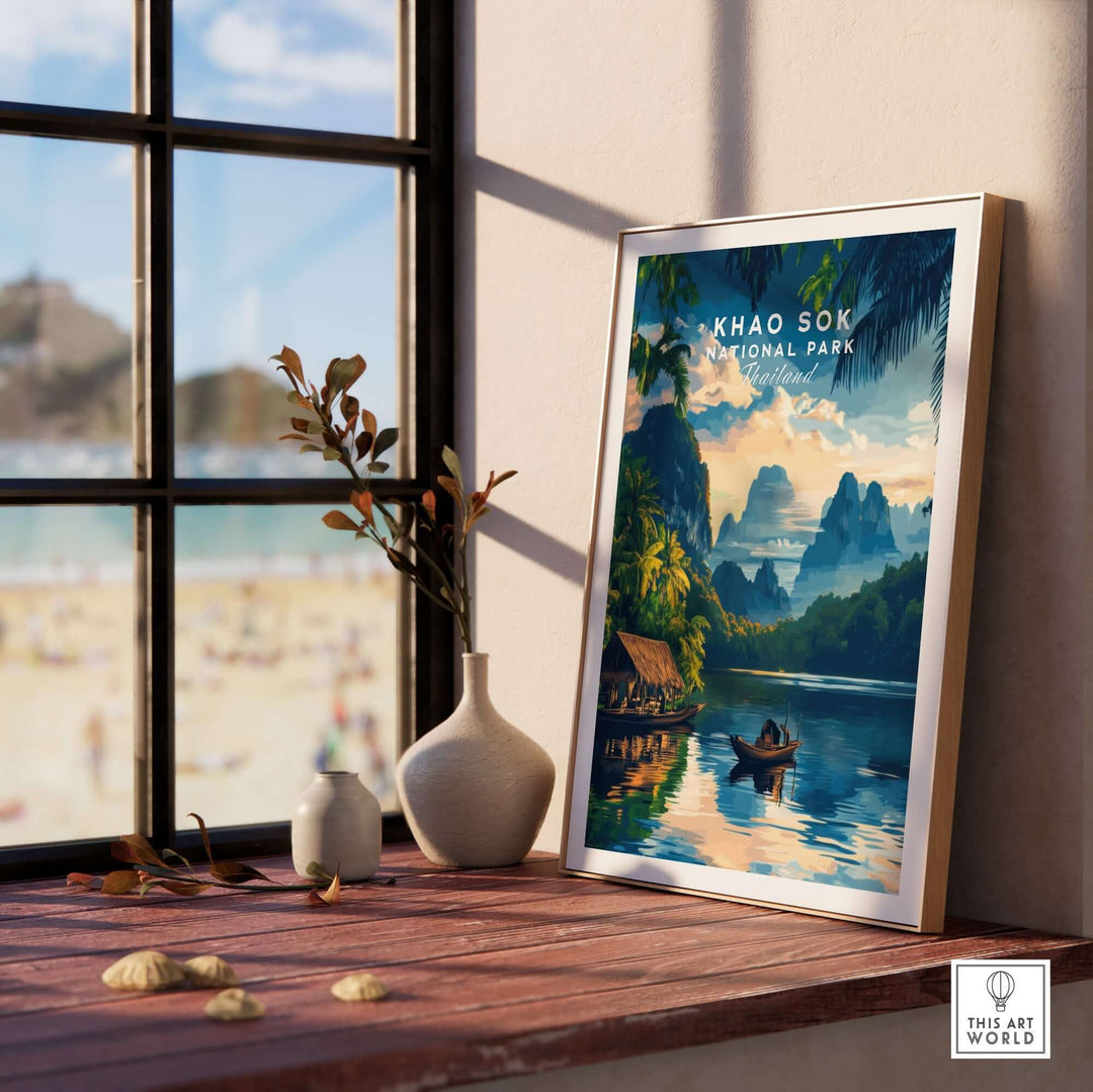 Khao Sok National Park art print displayed on a wooden table with a scenic view outside a window.