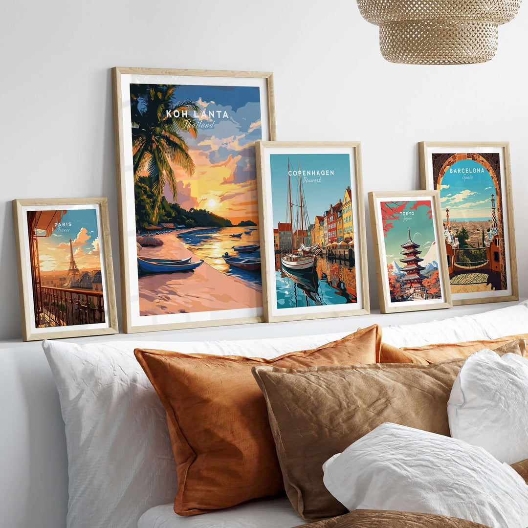 Koh Lanta travel print showcased among other city travel prints on a stylish sofa with warm-colored cushions.