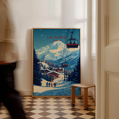 La Tania Wall Art Ski Print showcased in a bright interior with skiers and a ski lift in an alpine setting.