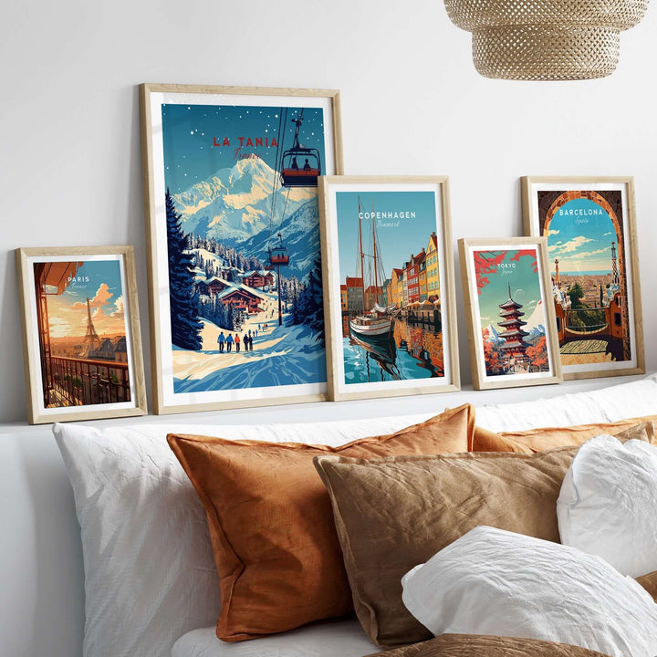 La Tania Wall Art Ski Print displayed among other city-themed prints on a cozy bed with decorative pillows.