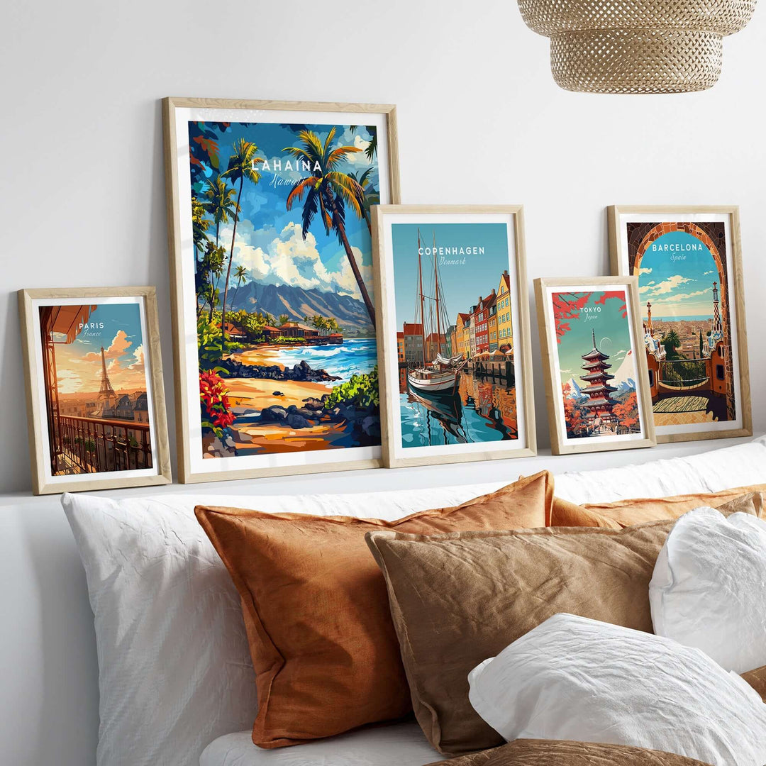 Lahaina print artwork displayed in wooden frames above a cozy bed with decorative pillows.