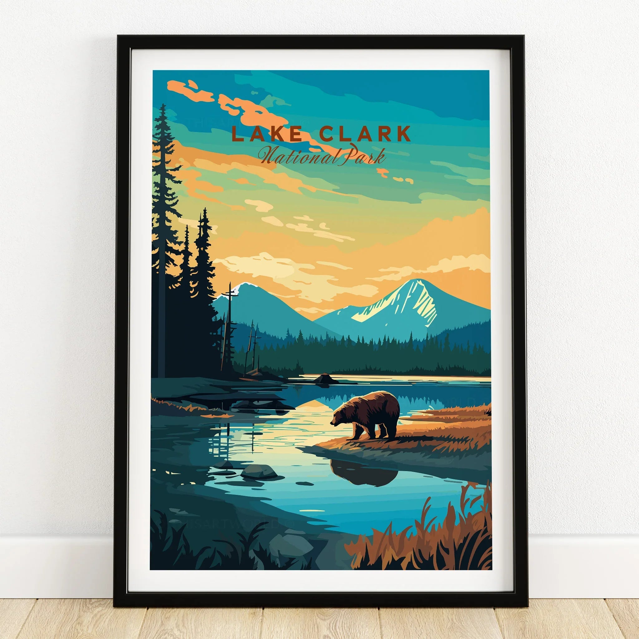 Lake Clark National Park art print with bear, lake, and mountains in black frame on wooden floor