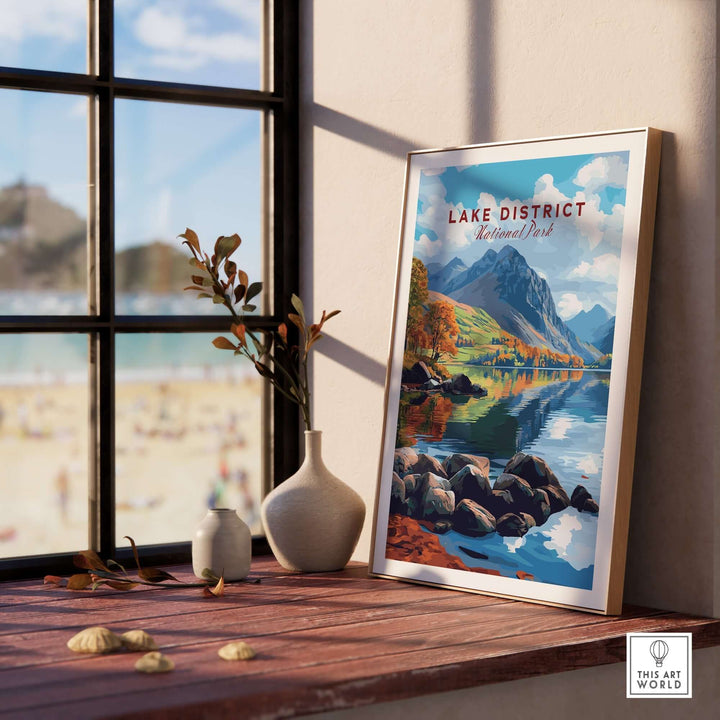 Lake District travel print displayed on a wooden table beside a window, capturing stunning landscapes and serene nature.