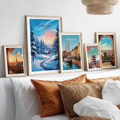 Lapland Poster Print collection displayed on a cozy bed with decorative pillows, showcasing Nordic landscapes and architecture.