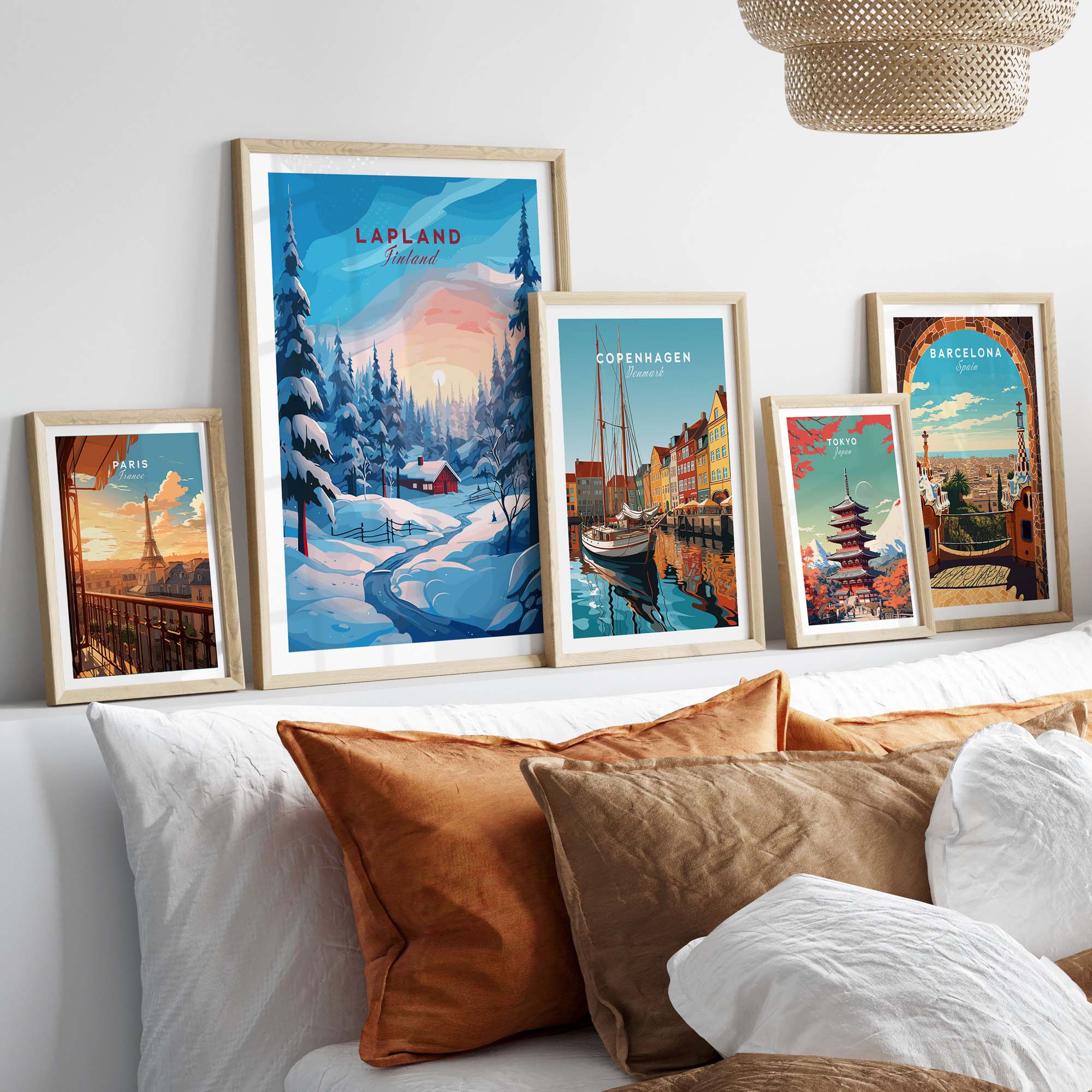Lapland Poster Print collection displayed on a cozy bed with decorative pillows, showcasing Nordic landscapes and architecture.