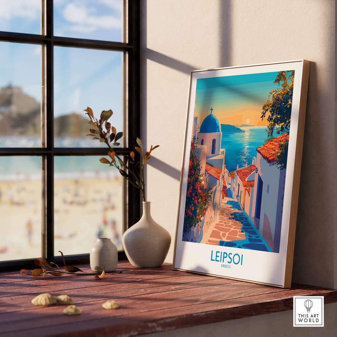 Leipsoi Greece wall art print framed on a wooden table near a window, showcasing vibrant colors and island beauty.