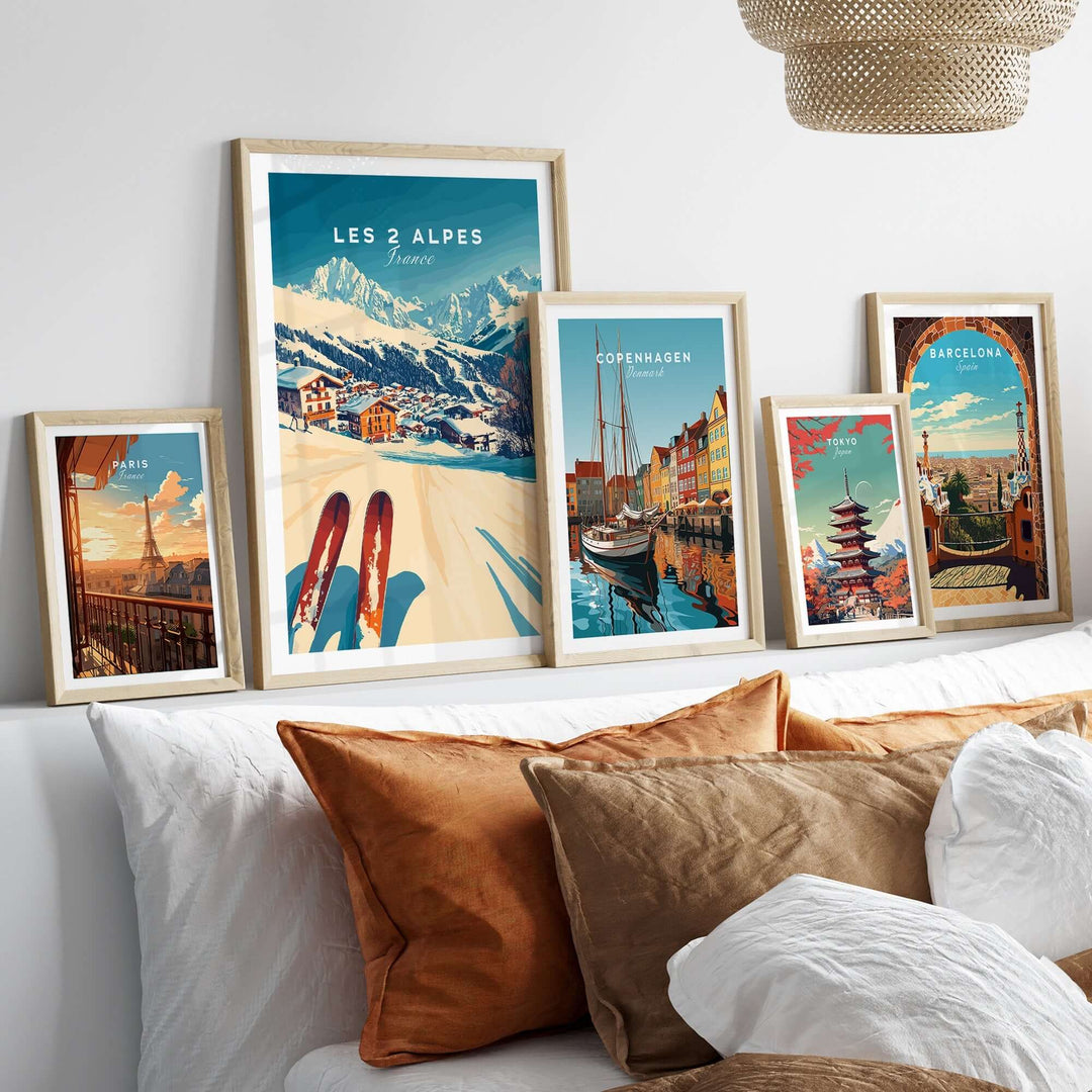 Art ski prints on a wall display, featuring Les 2 Alpes and other vibrant cityscapes, enhancing ski decor.