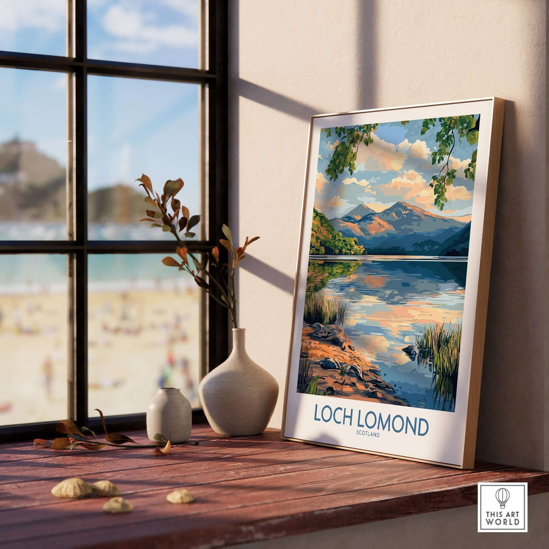 Loch Lomond Scotland travel poster displayed on a windowsill, showcasing serene lake and mountain scenery.