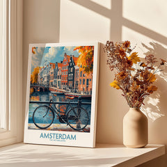 Bright Amsterdam Canal Poster - Colourful Dutch Houses Reflecting on Water Art displayed beside a vase with flowers.