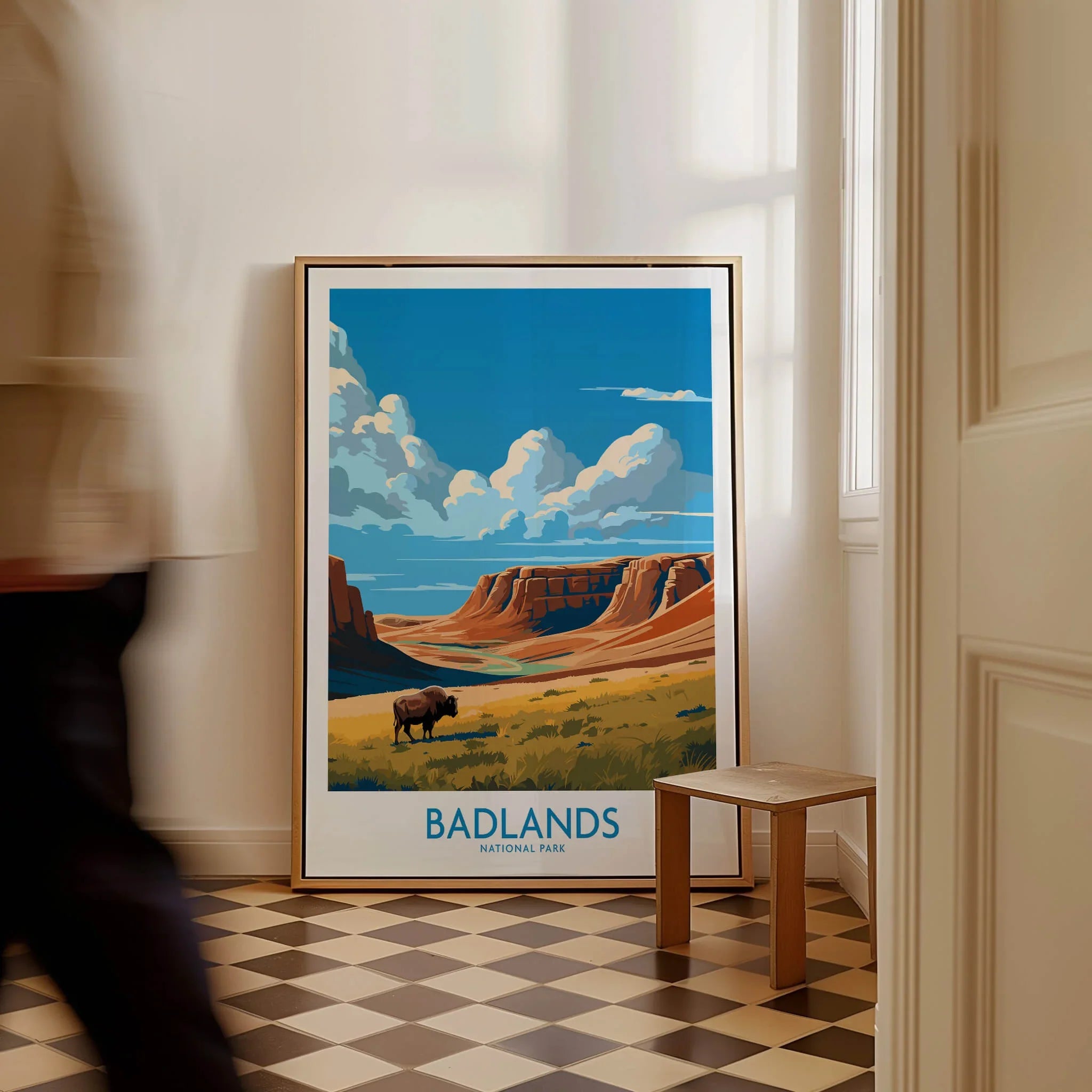 Framed Badlands National Park art print with bison, placed on floor in sunlit hallway.
