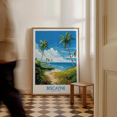 Framed Biscayne National Park travel poster with palm trees and ocean, resting on floor