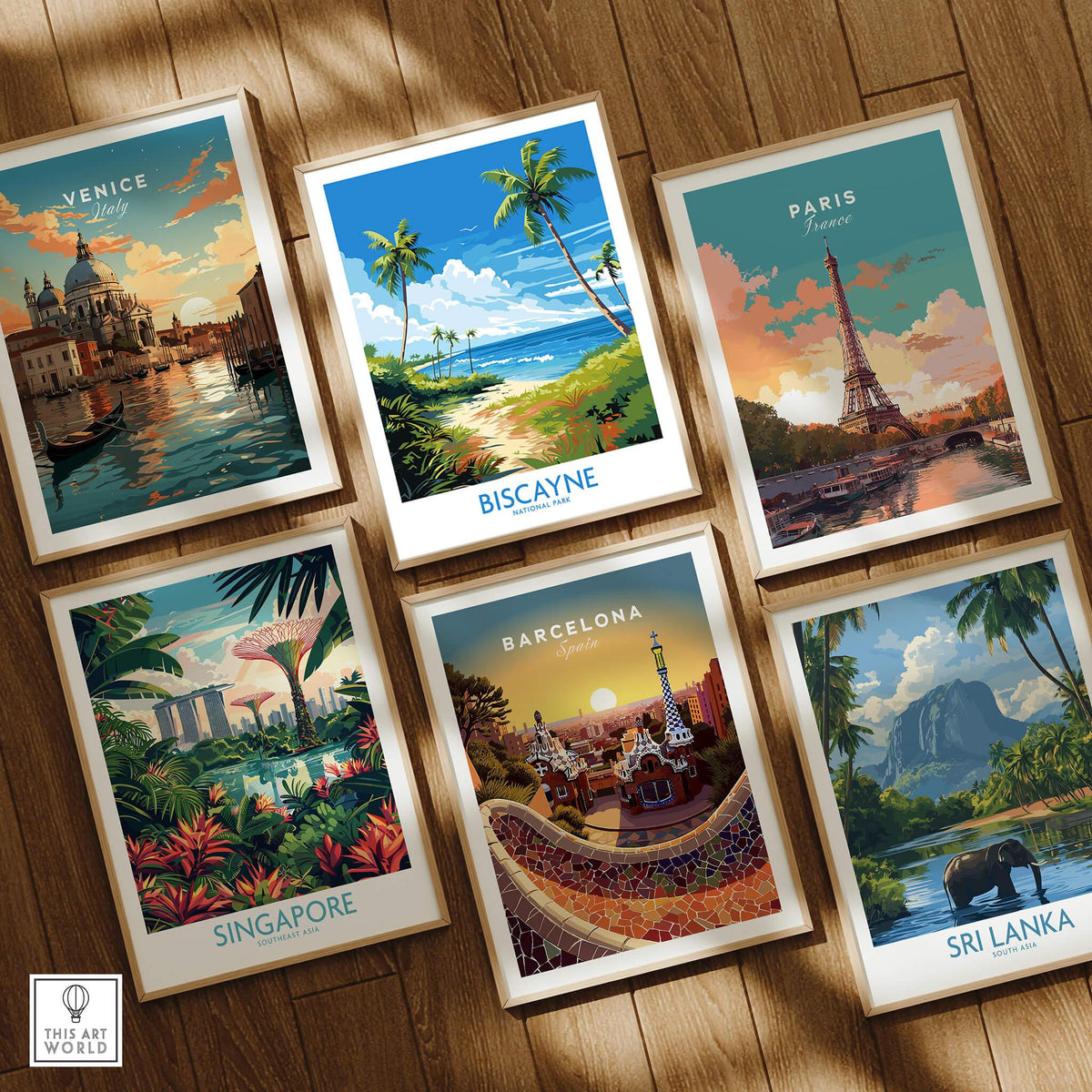 Set of six framed travel posters on wooden floor, featuring Venice, Biscayne, Paris, Singapore, Barcelona, and Sri Lanka wall art prints.