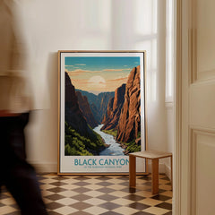 Framed Black Canyon National Park art print on floor in bright room, man walking past.