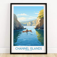 Channel Islands National Park art print in black frame, showing a kayaker on blue water between cliffs, on a wooden floor.