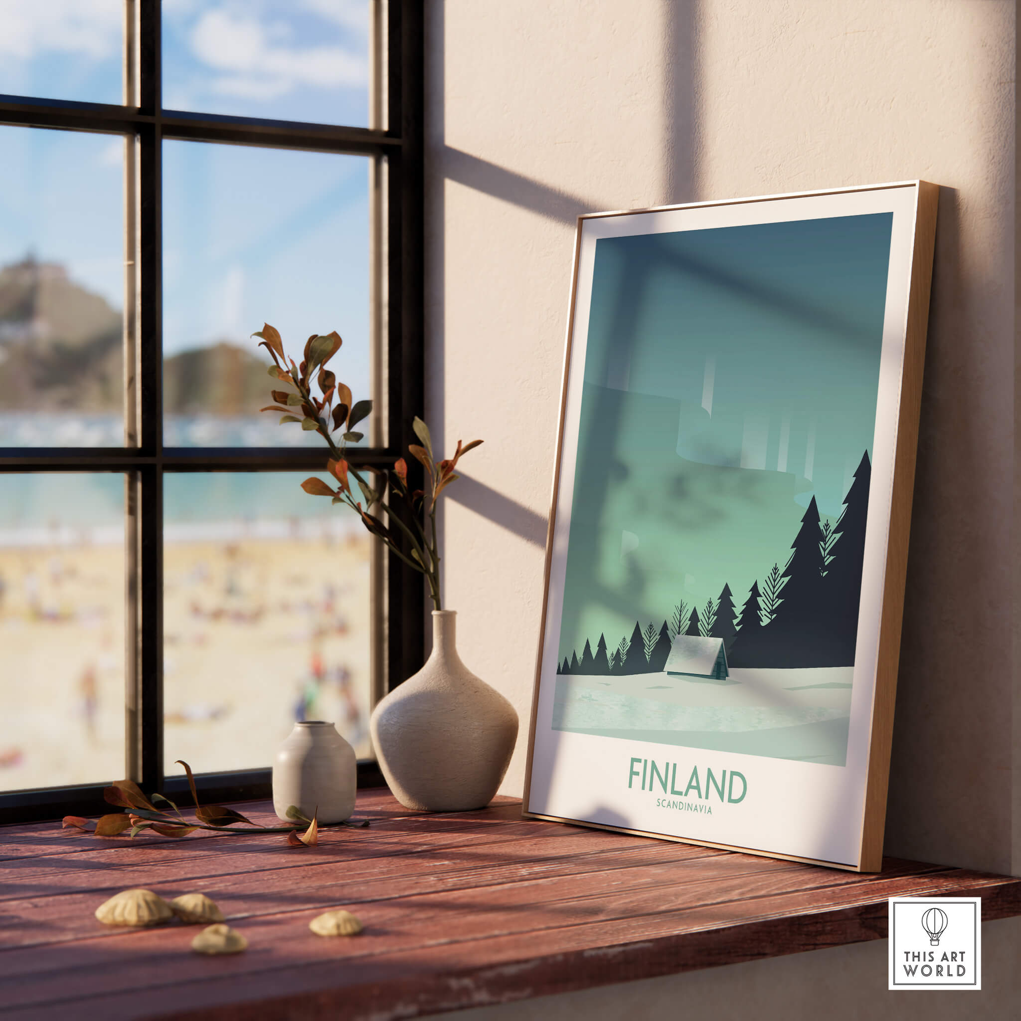 Finland Print Travel Poster displayed on a wooden table with a view of the beach, featuring minimalist design and nature elements.