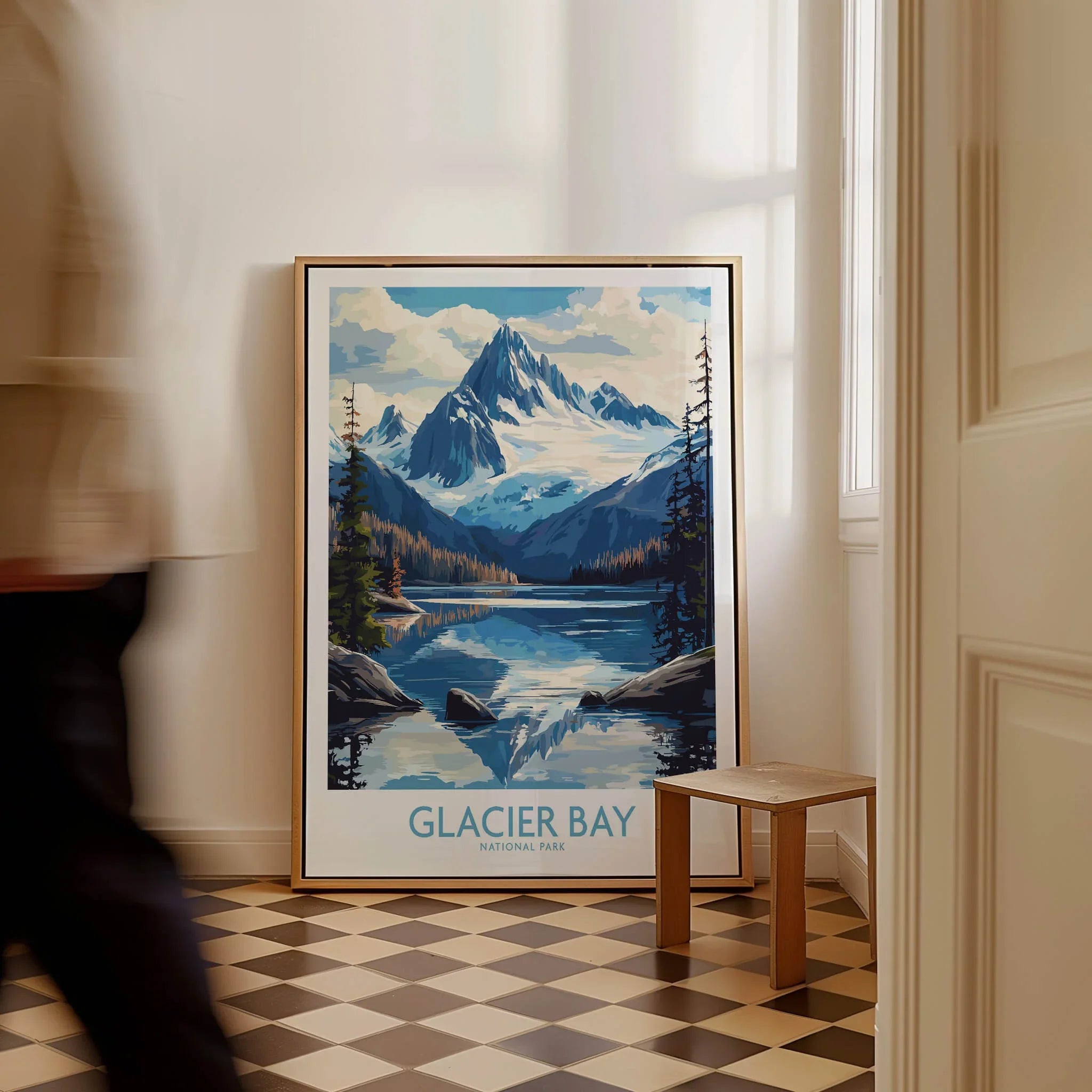 Framed Glacier Bay National Park travel poster on floor in bright modern room, man walking past.