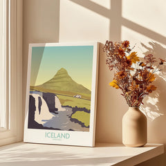 Iceland Kirkjufell travel poster with mountain, waterfall, and car, styled on windowsill with dried flowers.