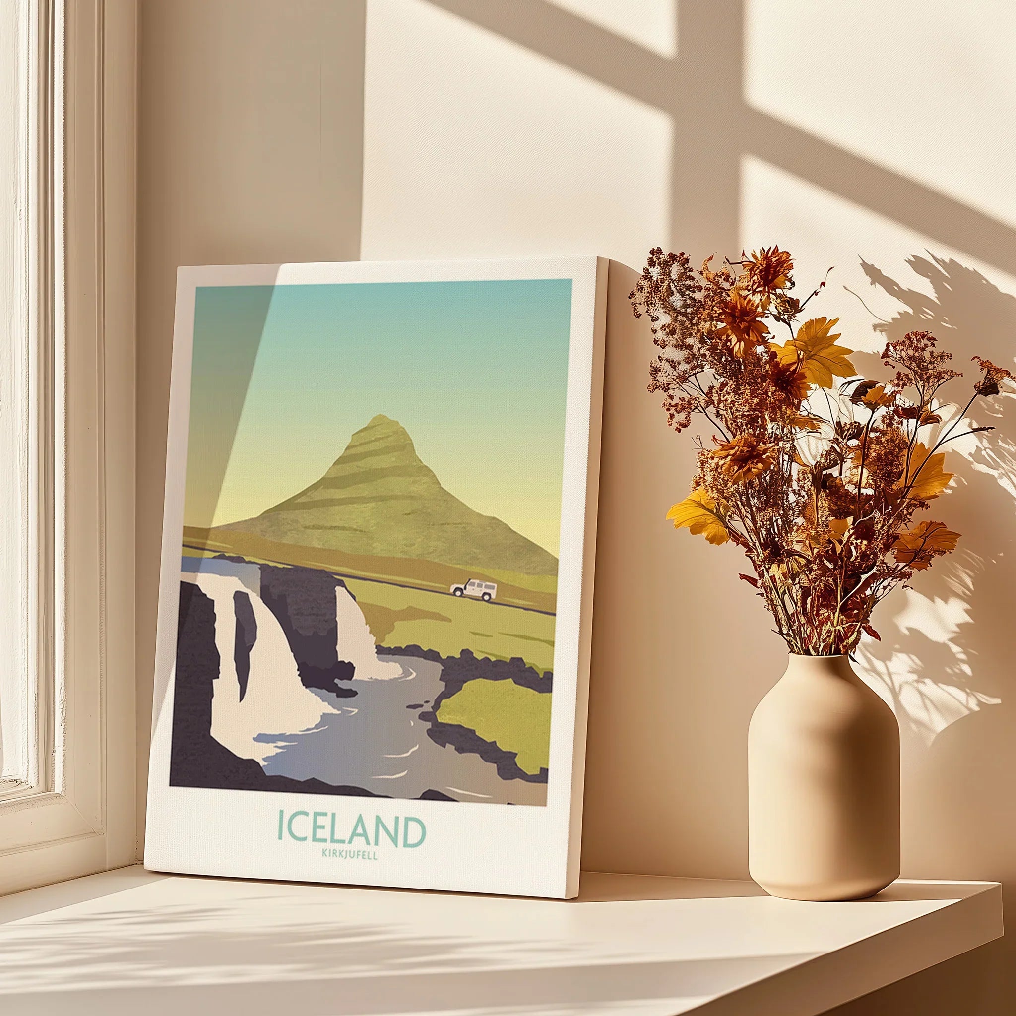 Iceland Kirkjufell travel poster with mountain, waterfall, and car, styled on windowsill with dried flowers.