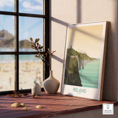 Ireland Print Travel Poster on a windowsill showcasing Cliffs of Moher and a beach view, perfect for wall art.