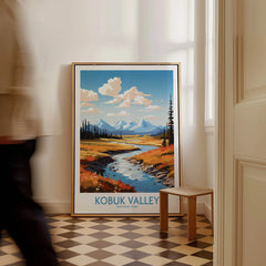 Framed Kobuk Valley National Park travel poster on floor, man walking past in hallway.