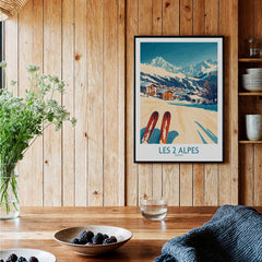 Les 2 Alpes Ski Poster Print displayed in a cozy wooden setting with ski equipment and fresh flowers.
