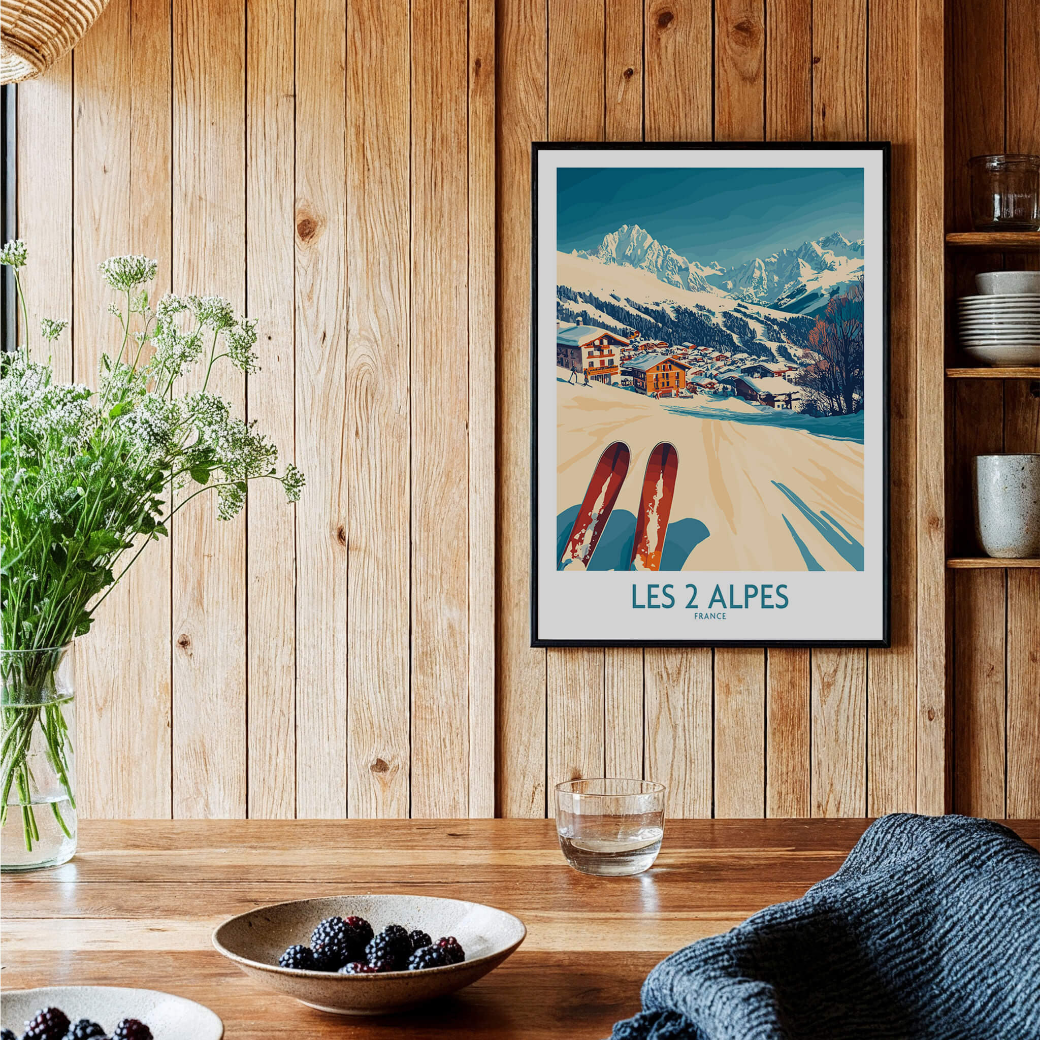 Les 2 Alpes Ski Poster Print displayed in a cozy wooden setting with ski equipment and fresh flowers.