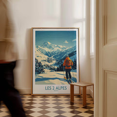 Les 2 Alpes Poster France showcasing a skier against stunning snowy mountains in a stylish interior setting.