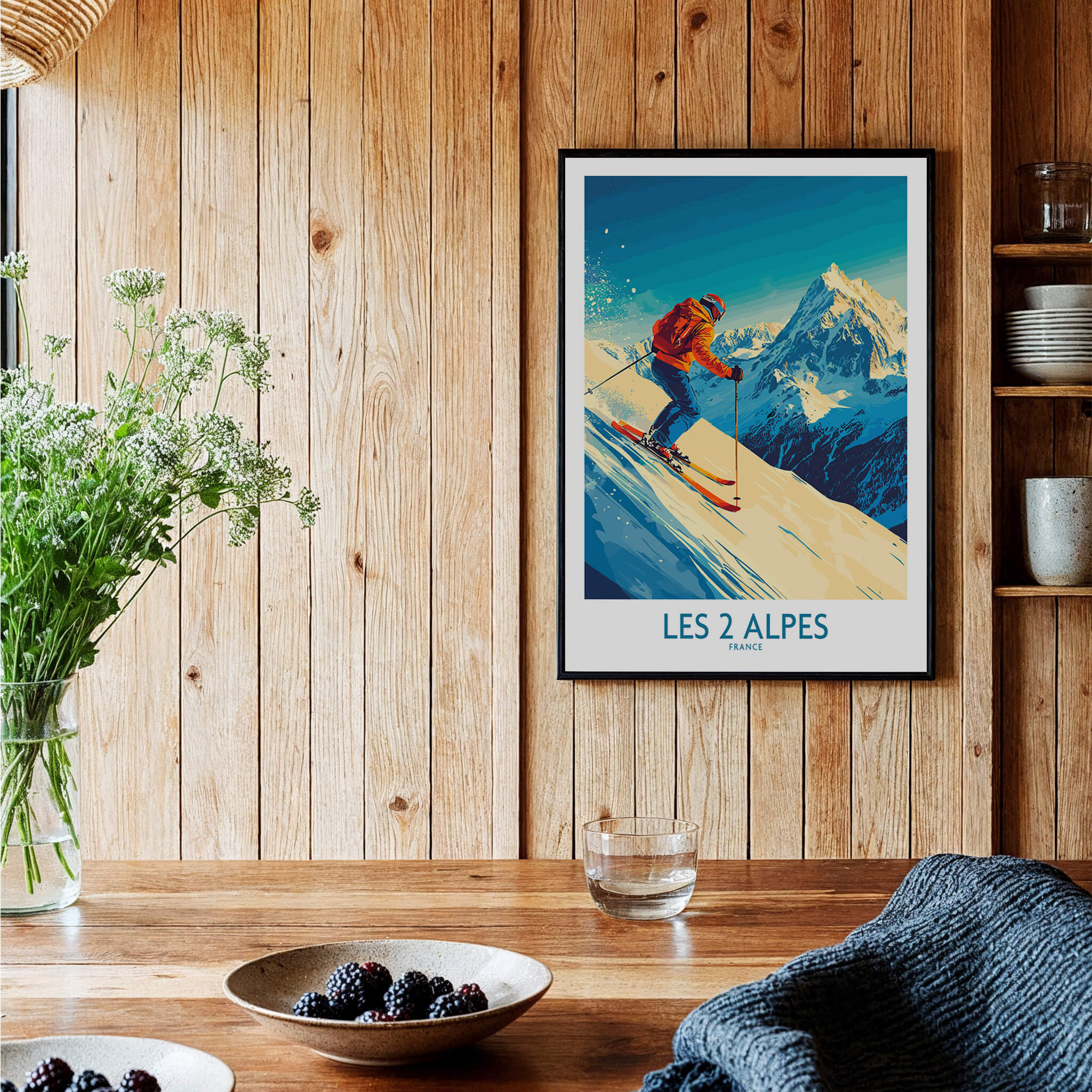 Les 2 Alpes Wall Art Ski Poster displayed in a cozy interior setting, showcasing skiing and beautiful mountain scenery.