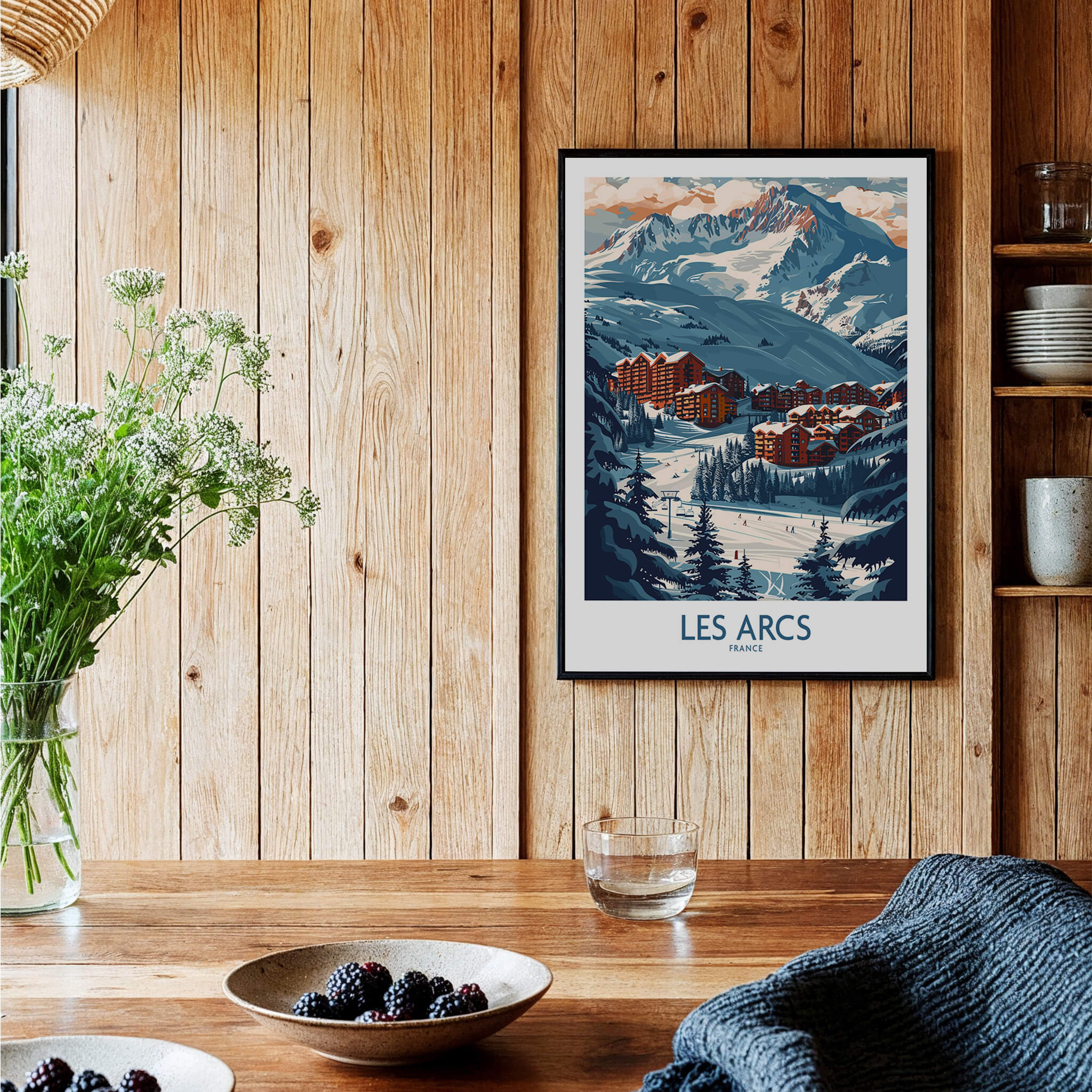 Les Arcs Poster France displayed in a cozy wooden interior with plants and pottery, showcasing stunning ski resort landscape.