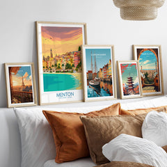 Menton Cote d'Azur Poster Print displayed among other travel posters on a modern couch.