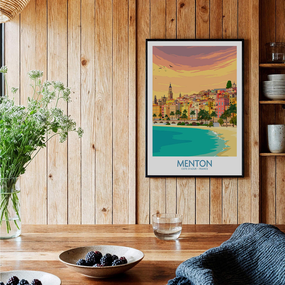 Menton Cote d'Azur Poster Print displayed in a stylish room with wooden decor and plants.