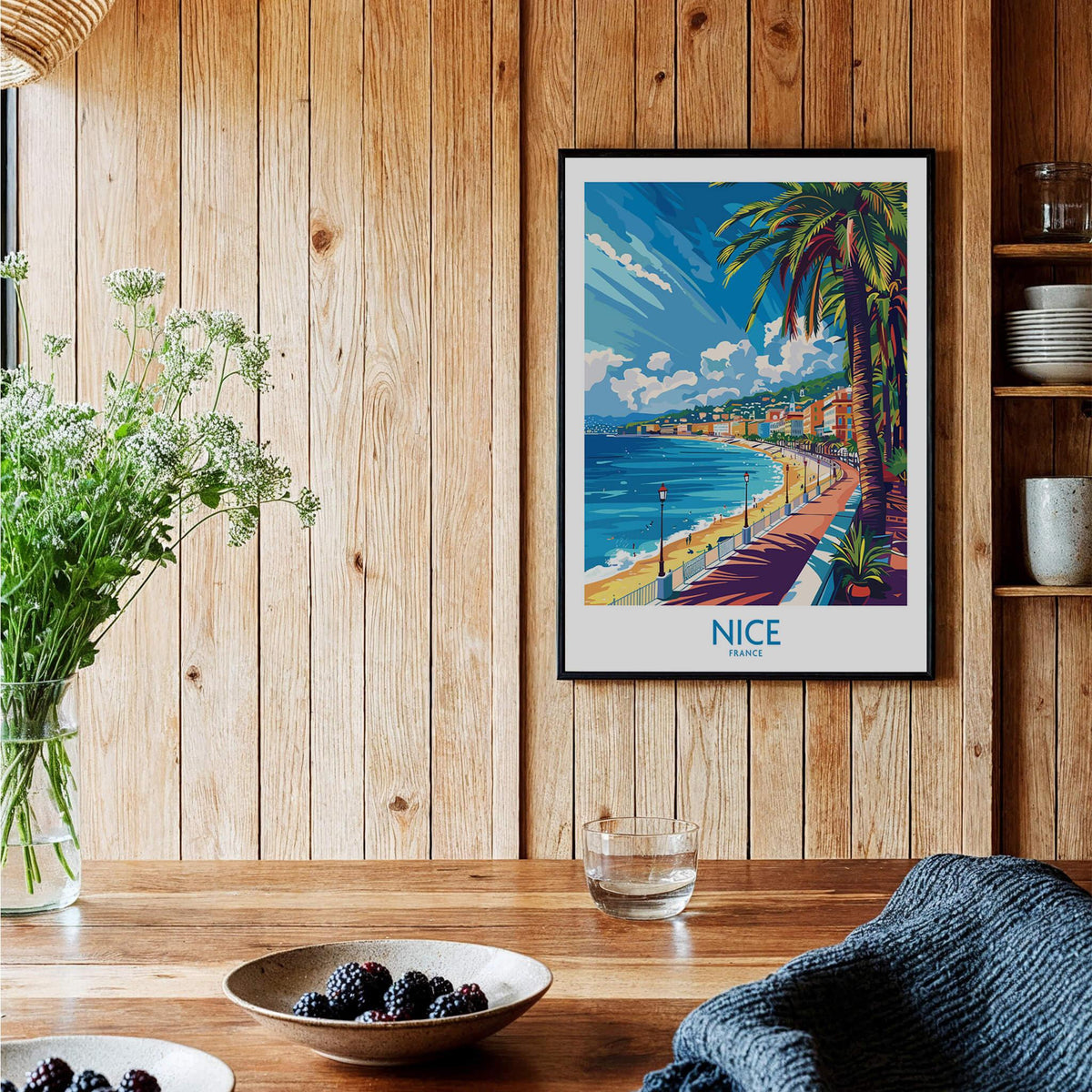 Nice Wall Art Poster - France displayed in a cozy room with wooden decor and vibrant coastal scenery.